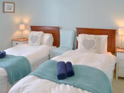 a bedroom with two beds with blue towels on them at Tregatta Terrace in Tintagel