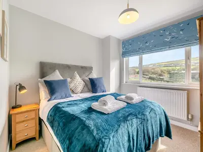 a bedroom with a bed with towels on it at Trewethett Farm in Forrabury