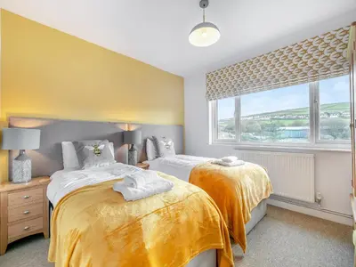 a bedroom with two beds and a window at Trewethett Farm in Forrabury