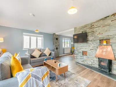 a living room with a couch and a fireplace at Trewethett Farm in Forrabury