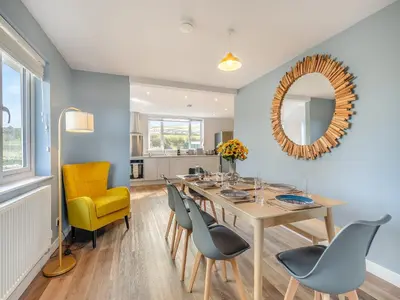 a dining room with a table and chairs and a mirror at Trewethett Farm in Forrabury