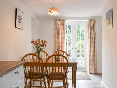 a dining room with a table and chairs and a window at Dove Cottage in Lezant