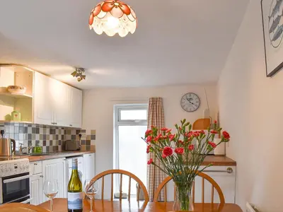 a kitchen with a table with a vase of flowers at Dove Cottage in Lezant