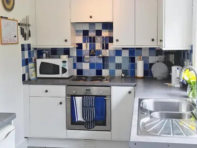 a kitchen with a sink and a microwave at Keeper's Cottage in Helford Passage