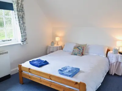 a bedroom with a bed with two towels on it at Keeper's Cottage in Helford Passage