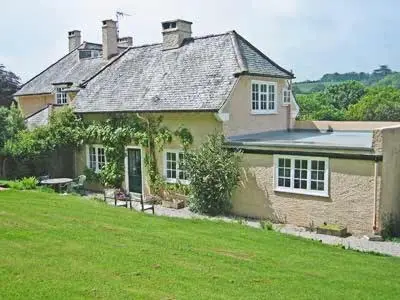 a large house with a green lawn in front of it at Keeper's Cottage in Helford Passage