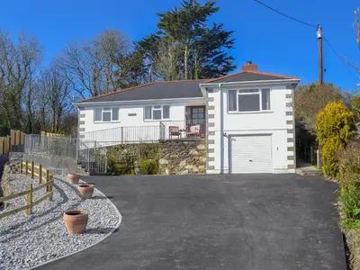 a white house with a gate and a driveway at Ponsgwedhen in Coverack