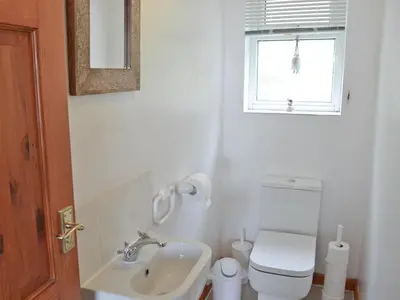 a bathroom with a sink and a toilet and a window at Ponsgwedhen in Coverack