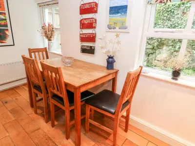 a dining room with a wooden table and chairs at Honeysuckle Cottage in St. Agnes