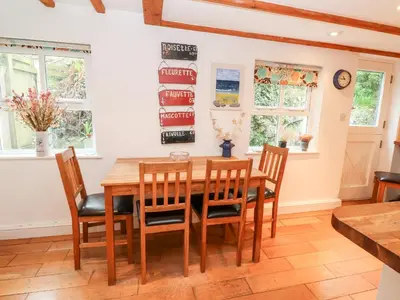 a dining room with a wooden table and chairs at Honeysuckle Cottage in St. Agnes