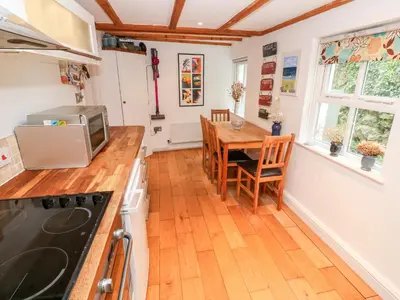 a kitchen and dining room with a table and a stove at Honeysuckle Cottage in St. Agnes