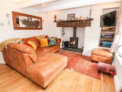 a living room with a couch and a fireplace at Honeysuckle Cottage in St. Agnes