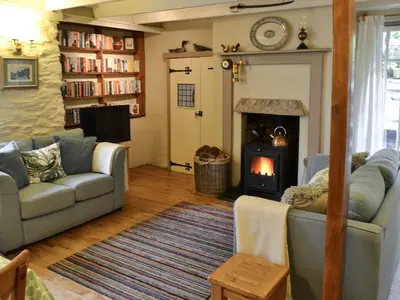 a living room with a couch and a fireplace at Fairmaiden in Polruan