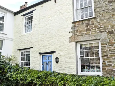 a white brick house with a blue door at Fairmaiden in Polruan