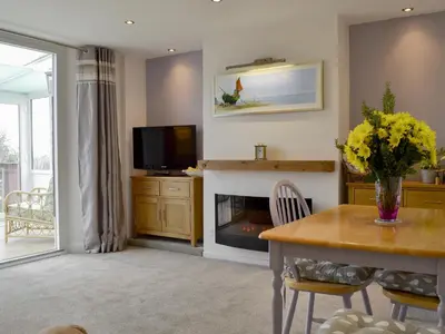 a living room with a fireplace and a table and a television at Greenhaven in Par