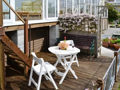 a white table and two chairs on a porch at Greenhaven in Par