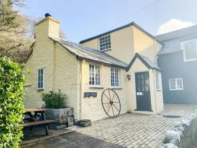 a building with a door and a picnic table at Liam Cottage - Cv13 in Liskeard