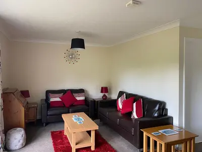 a living room with a black couch and red pillows at Tresco - B6520 in Saint Cleer