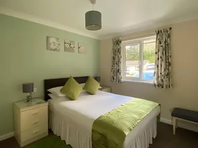 a bedroom with a large bed and a window at Tresco - B6520 in Saint Cleer