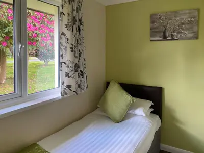 a bed with a pillow sitting next to a window at Tresco - B6520 in Saint Cleer