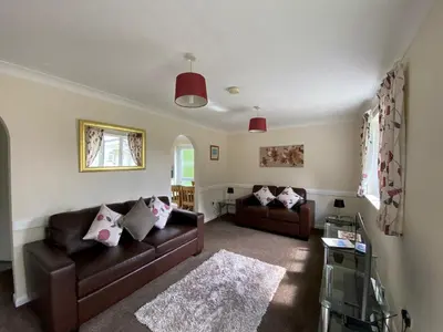 a living room with two brown couches and a rug at Pencarrow - B6521 in Saint Cleer