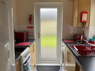 a kitchen with a sink and a door with a window at Heligan - B6522 in Saint Cleer