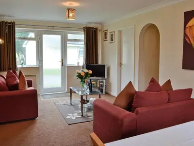 a living room with two red couches and a tv at Trebah - B5623 in Saint Cleer