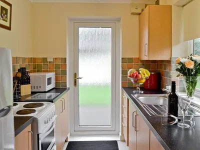 a kitchen with a sink and a door with a window at Trebah - B5623 in Saint Cleer