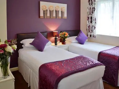 two beds in a room with purple walls at Trebah - B5623 in Saint Cleer