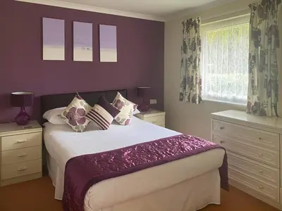 a bedroom with a bed with purple walls and windows at Eden - B6526 in Saint Cleer