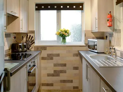 a kitchen with a sink and a window with a vase of flowers at Trevarno - B6527 in Saint Cleer