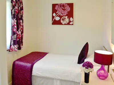 a bedroom with a bed and a table with a lamp at Trevarno - B6527 in Saint Cleer