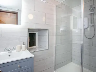 a white bathroom with a shower and a sink at Alyshan in Merrymeet