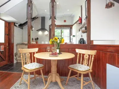 a kitchen with a table with chairs and a vase of flowers at Alyshan in Merrymeet