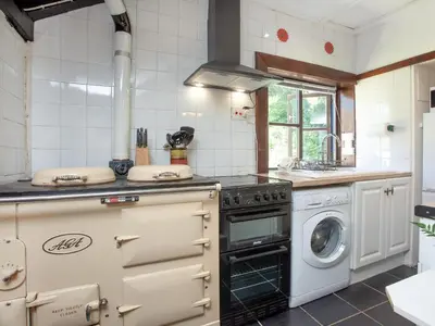 a kitchen with a stove and a washing machine at Alyshan in Merrymeet