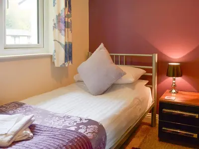 a small bedroom with a bed and a window at Talland Bay in Saint Cleer