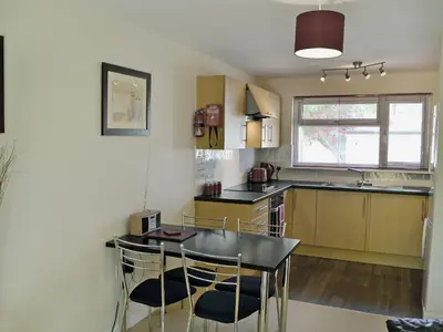 a kitchen with a table and chairs in a room at Seaton in Saint Cleer