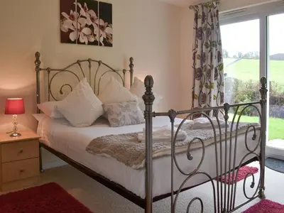 a bedroom with a bed and a window at Seaton in Saint Cleer