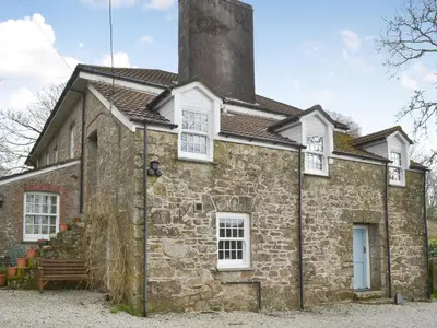 an old stone house with a chimney at Trekeive Cottage in Saint Cleer