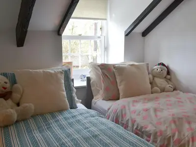 a bedroom with two teddy bears sitting on a bed at Trekeive Cottage in Saint Cleer