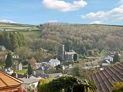 a small town with houses and a hill in the background at Tripp Cottage in Saint Neot