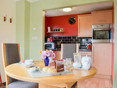 a kitchen with a wooden table with food on it at Tripp Cottage in Saint Neot