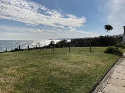 a grassy field with a view of the ocean at 3 The Coastguards in Downderry