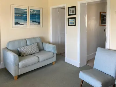a living room with a couch and a chair at 3 The Coastguards in Downderry