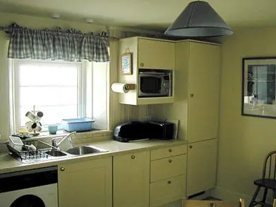 a kitchen with a sink and a microwave at 3 The Coastguards in Downderry