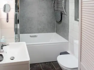 a bathroom with a tub and a toilet and a sink at Trenay Barns Cottage in Warleggan