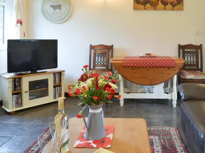 a living room with a vase of flowers on a table at Trenay Barns Cottage in Warleggan