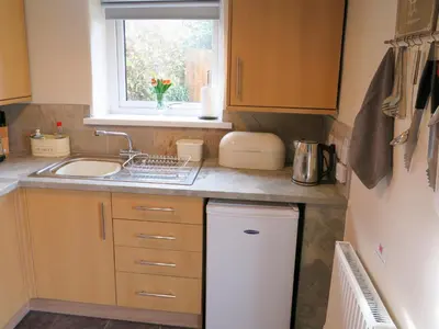 a small kitchen with a sink and a window at Trenay Barns Cottage in Warleggan