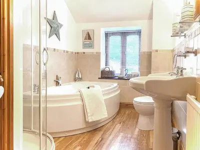 a bathroom with a tub and a toilet and a sink at Penty Rosen in Pentewan