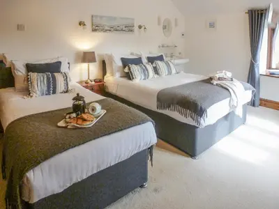 a hotel room with two beds with a tray of food at Anneth Lowen in Pentewan